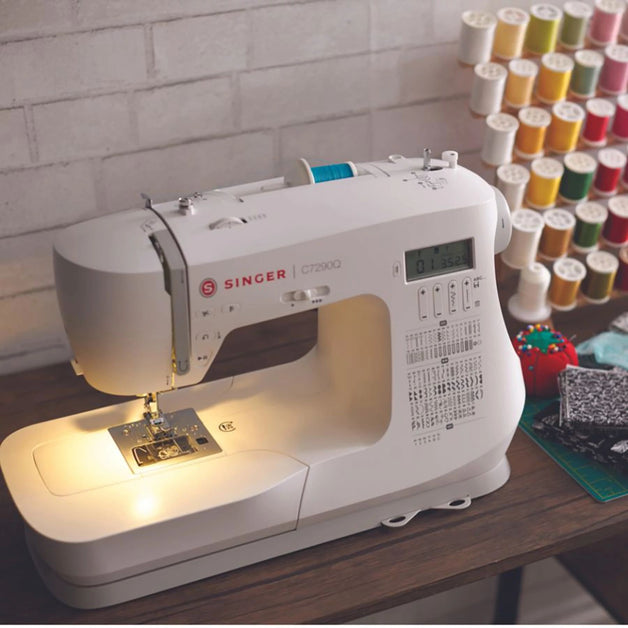 C7290Q Sewing and Quilting Machine sitting on a table with its led light turned on.