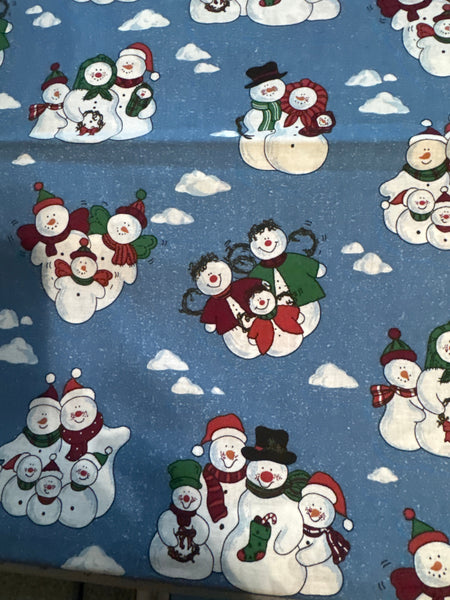 Diseño vintage con muñecos de nieve y nubes sobre fondo azul, 100 % algodón ligero. Precio por yarda.