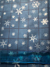 Motivos vintage de copos de nieve sobre fondo azul a cuadros. 100 % algodón ligero. Precio por yarda.