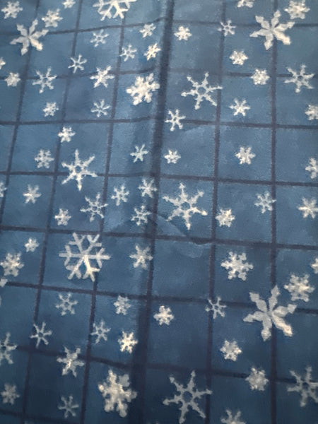 Motivos vintage de copos de nieve sobre fondo azul a cuadros. 100 % algodón ligero. Precio por yarda.