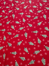 Miniárboles navideños de estilo vintage y copos de nieve sobre fondo rojo, 100 % algodón ligero. Precio por yarda.