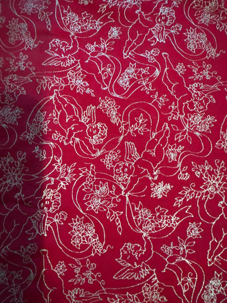 Estampado vintage en dorado metalizado con querubines, ángeles y cintas sobre fondo rojo, 100 % algodón ligero. Precio por yarda.