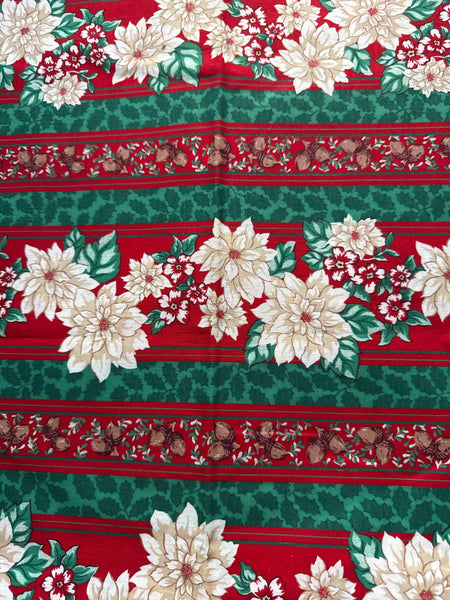 Estampado navideño vintage con poinsettias, bellotas y rayas en el borde. 100 % algodón ligero. Precio por yarda.
