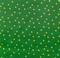 Pequeñas estrellas doradas metalizadas sobre fondo verde
