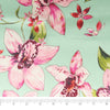 Stitch & Sparkle, 100 % poliéster, charmeuse de 57" de ancho, estampado de orquídeas sobre fondo menta, se vende por yardas