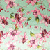 Stitch & Sparkle, 100 % poliéster, charmeuse de 57" de ancho, estampado de orquídeas sobre fondo menta, se vende por yardas