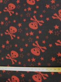Tejido de felpa con calaveras y estrellas negras y rojas