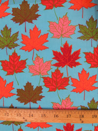 Tela de algodón y poliéster en color turquesa con motivos de hojas otoñales
