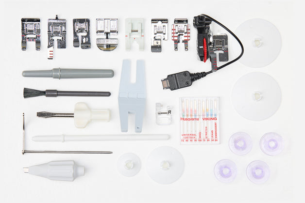 Colección de accesorios y herramientas para máquinas de coser sobre fondo blanco